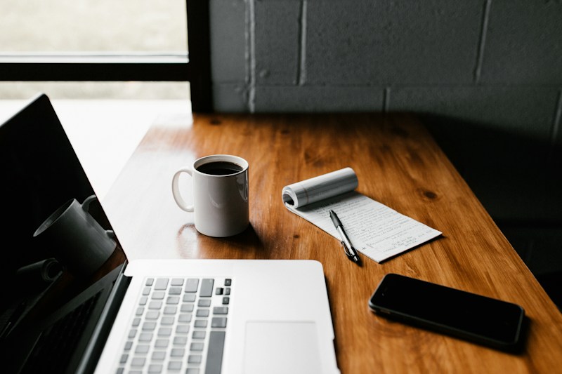 A notebook and a warm drink on a desk